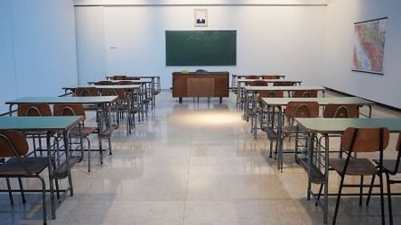 A classroom filled with student desks sits empty. 